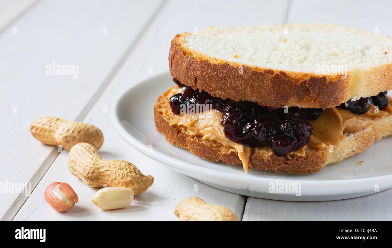 fast food, snack, beurre d'arachide et confiture de fruits sur une table en bois blanc Banque D'Images