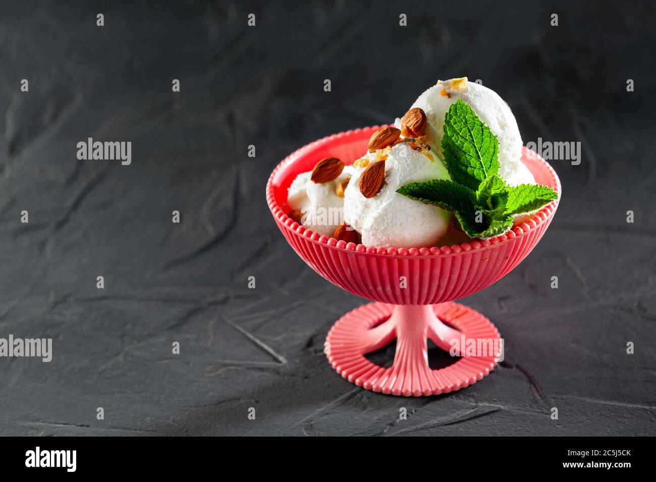 boules de crème glacée blanche se remplissant sur fond noir avec de la menthe, du chocolat et du cacao. Repas d'été et vue du dessus Banque D'Images