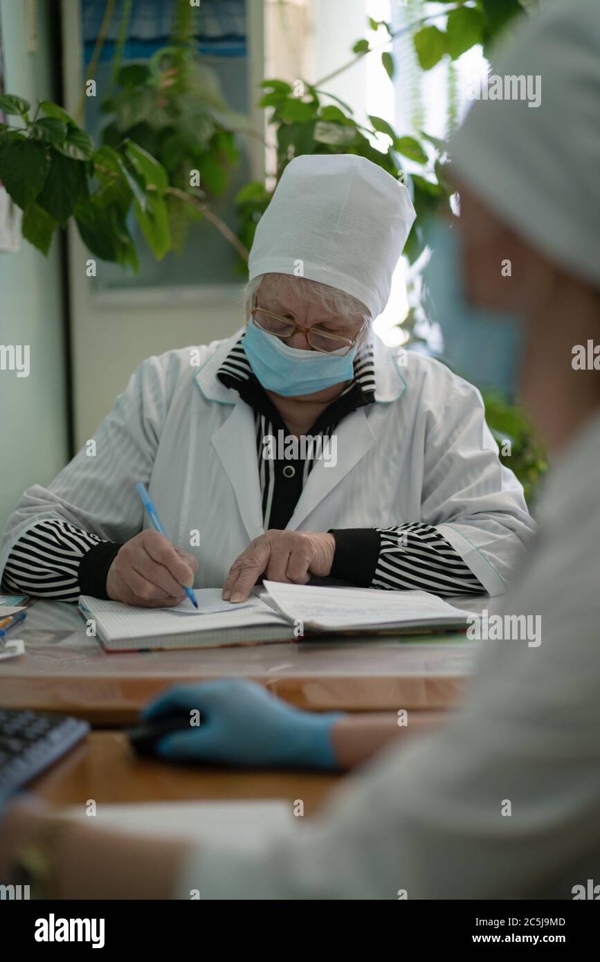 Une infirmière ou un médecin généraliste prend des notes sur la carte médicale. Médecin généraliste qui écrit sur la carte du patient. Hôpital de la ville. Mai 2020, Brovary Banque D'Images