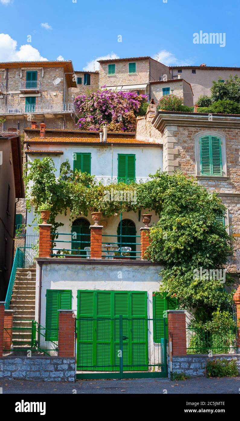 Vieilles ruelles historiques d'une ville toscane médiévale pleine de fleurs colorées et de soleil. Banque D'Images