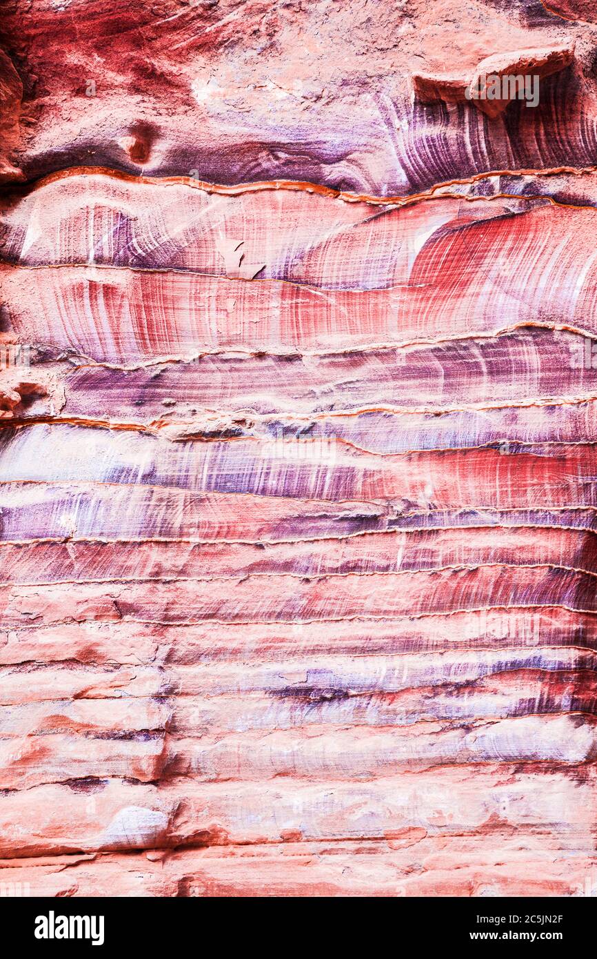 La surface rocheuse en grès rouge du canyon appelée Al Siq à l'entrée de la ville rose de Petra en Jordanie. Banque D'Images