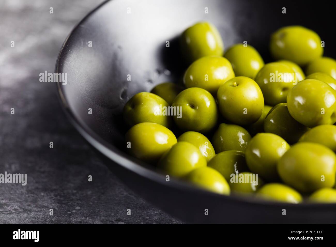 Olives vertes Nocellara dans un bol sur une table rustique, région des Pouilles Banque D'Images