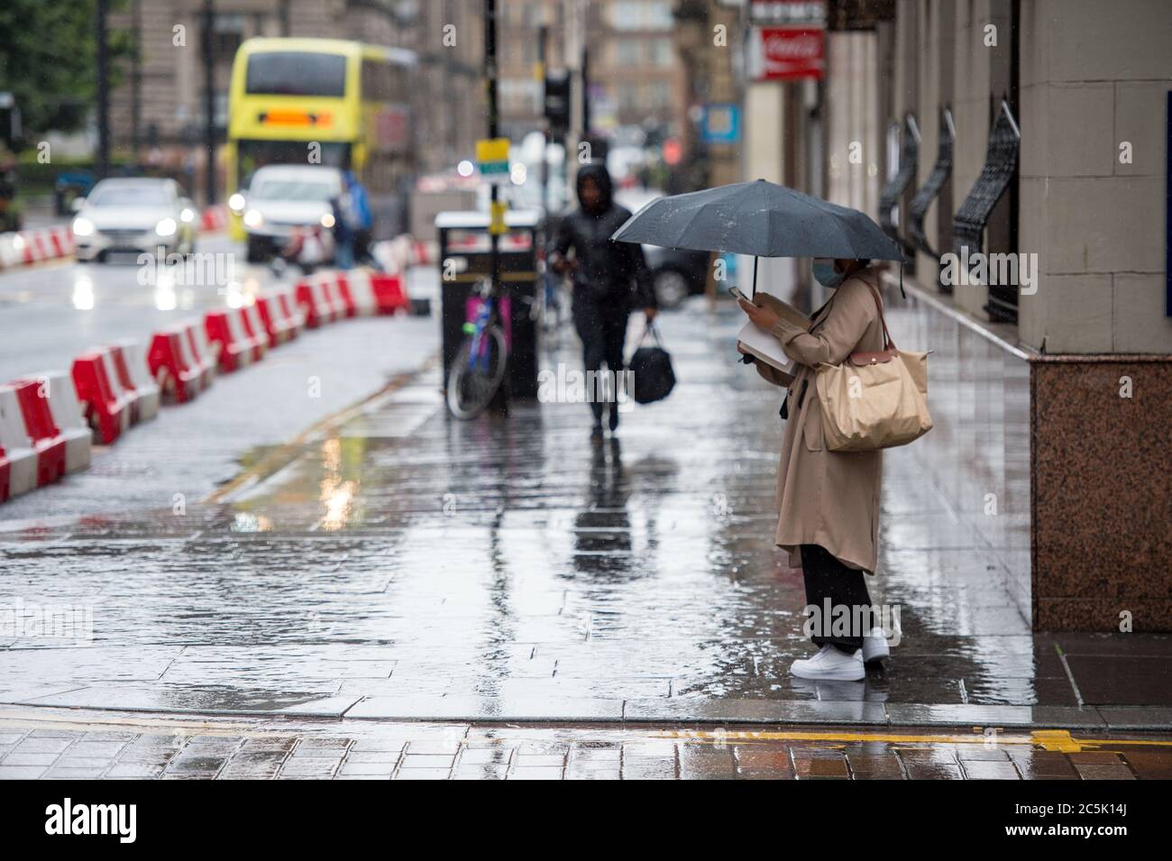Glasgow, Écosse, Royaume-Uni. 3 juillet 2020. Photo : zone commerçante de Buchanan Street avec des acheteurs qui bravent la pluie battante à l'aide de parasols et de couvre-visage qui deviendront obligatoires le 10 juillet prochain. Crédit : Colin Fisher/Alay Live News Banque D'Images