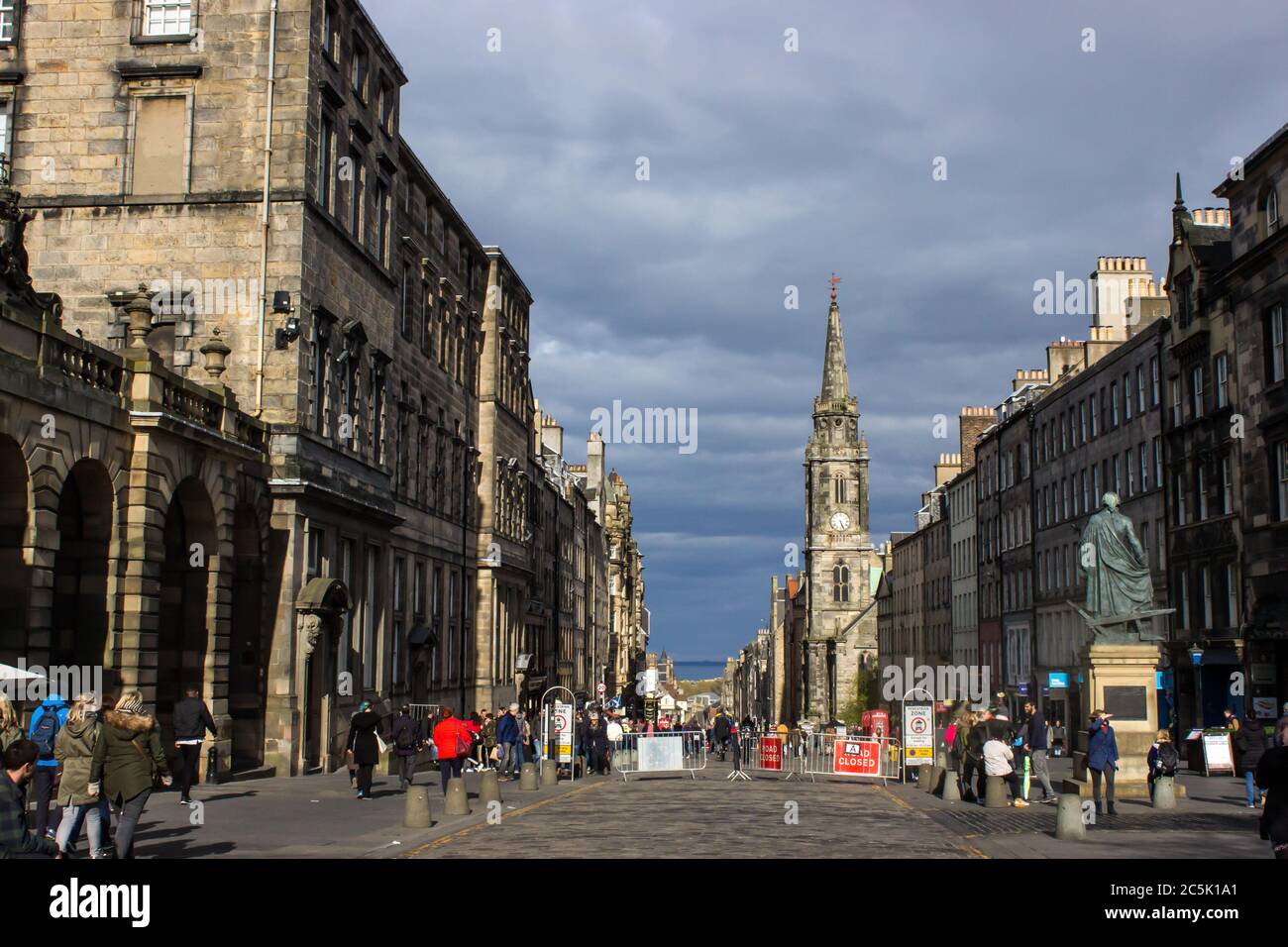 Un Royal Mile de lumière du soleil dans la vieille ville d'Édimbourg, avec des nuages sombres de tempête en arrière-plan Banque D'Images