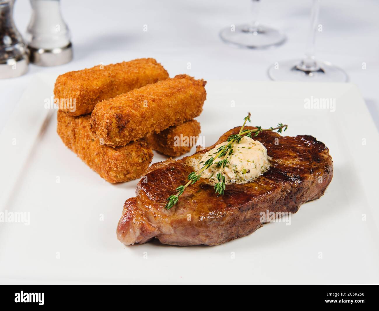 Steak avec beurre aux herbes et beignets de pommes de terre Banque D'Images