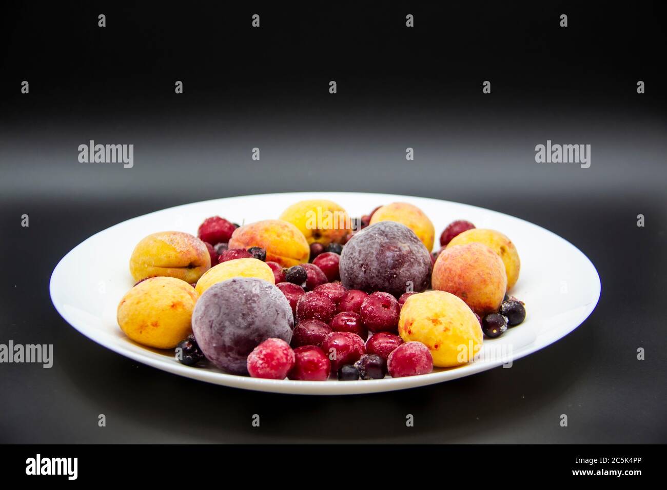 Un mélange de baies de cassis congelé, d'abricot, de prune, de cerise sur  la plaque blanche. Fruits surgelés du congélateur. Un fond avec prune  gelée, cassis, aprico Photo Stock - Alamy