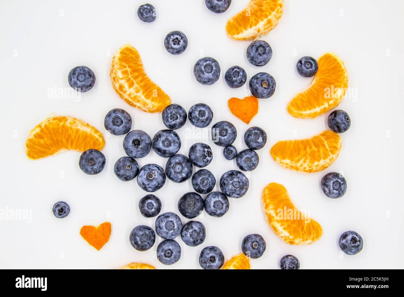 Bleuet frais avec tranches de mandarine sur fond blanc. Une composition de bleuets et de mandarines qui est biologique et saine. Le berr Banque D'Images