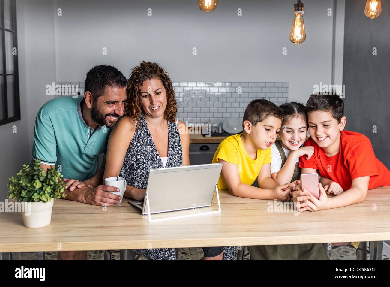 Une famille nombreuse et heureuse, connectée à la technologie Banque D'Images
