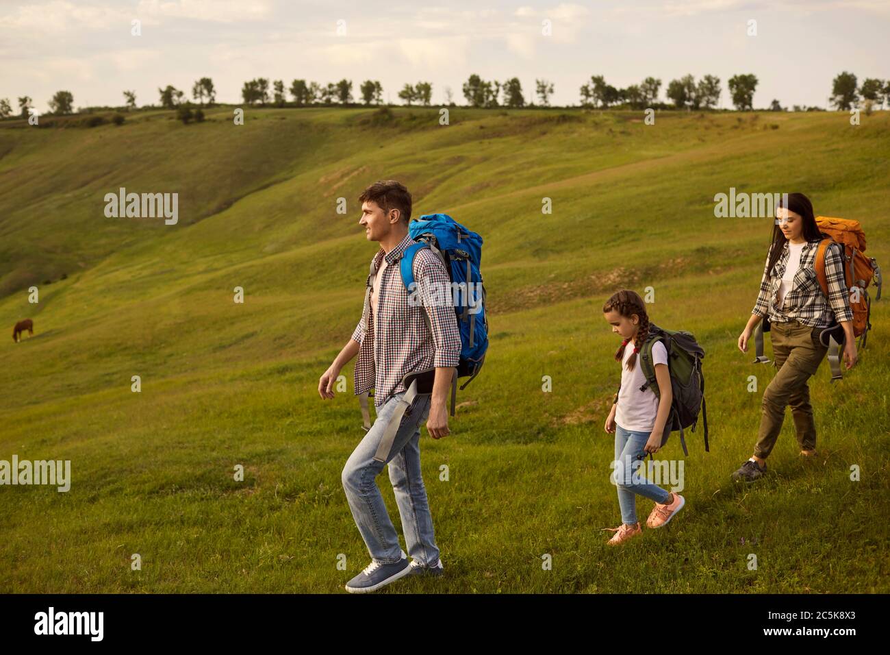 Famille heureuse avec enfants en randonnée dans les montagnes. Mère, père et fille randonnée à la campagne le jour de l'été Banque D'Images