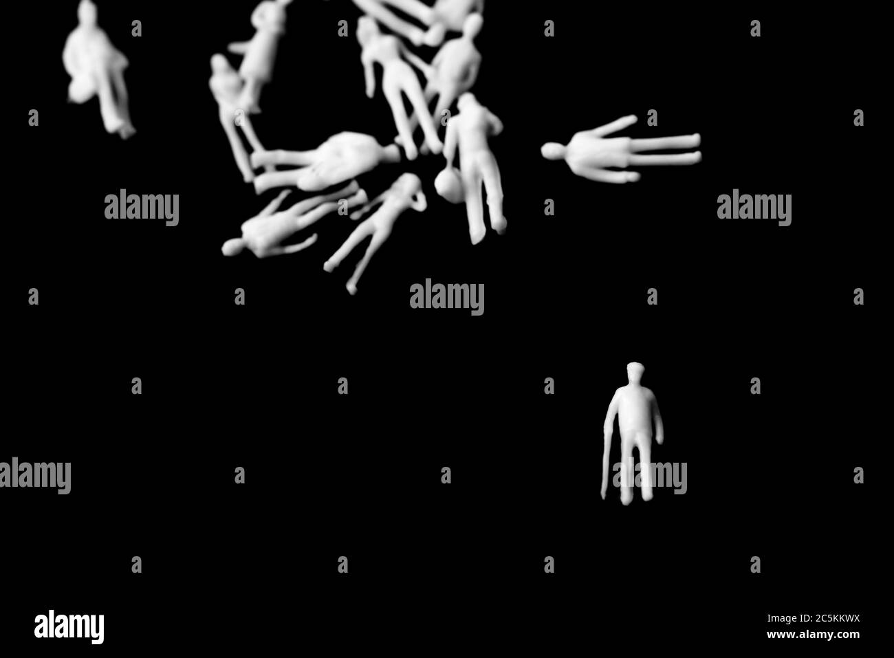 Covid-19, distance sociale, concept. Protection des personnes âgées contre le coronavirus.Figure d'homme âgé avec bâton de marche séparé d'un groupe de f Banque D'Images