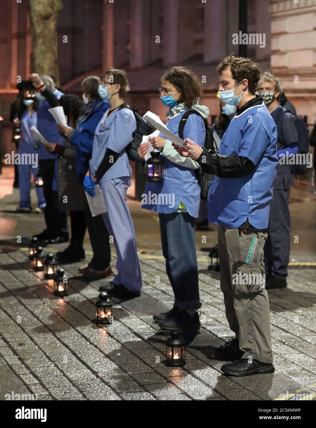 Le personnel du NHS et les militants de l'extérieur de Downing Street, Londres, lisant les noms du personnel du NHS qui est décédé à la suite du coronavirus, dans le cadre d'un défilé aux chandelles de l'hôpital St Thomas à Downing Street, Où ils tiennent une vigile pour ceux qui sont morts à la suite du coronavirus et marquant le 72e anniversaire du NHS. Chaque lanterne représente 1000 personnes décédées de COVID-19 au Royaume-Uni. Banque D'Images