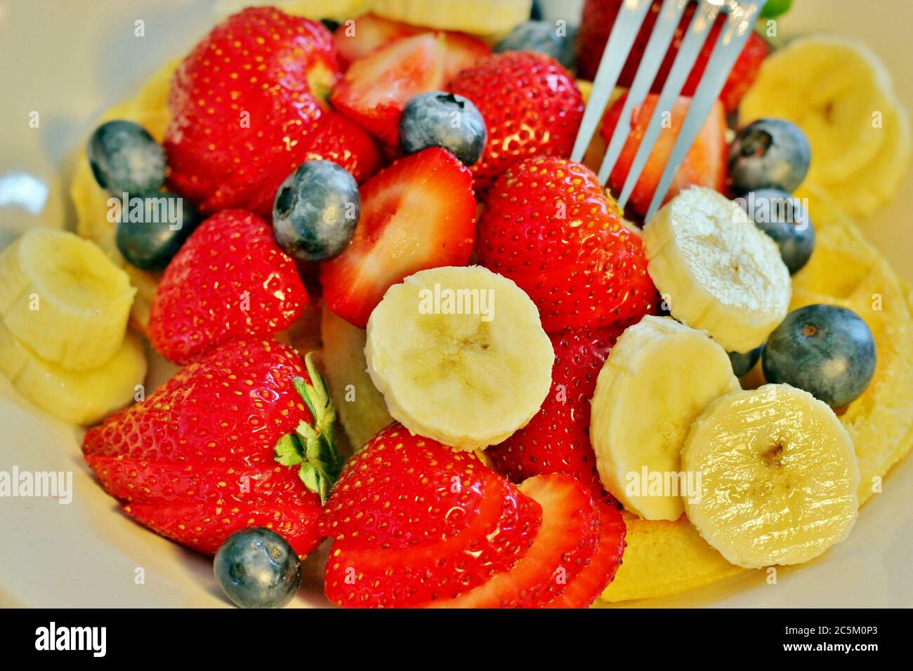 Gaufres au petit déjeuner garnies de baies et de bananes; Banque D'Images