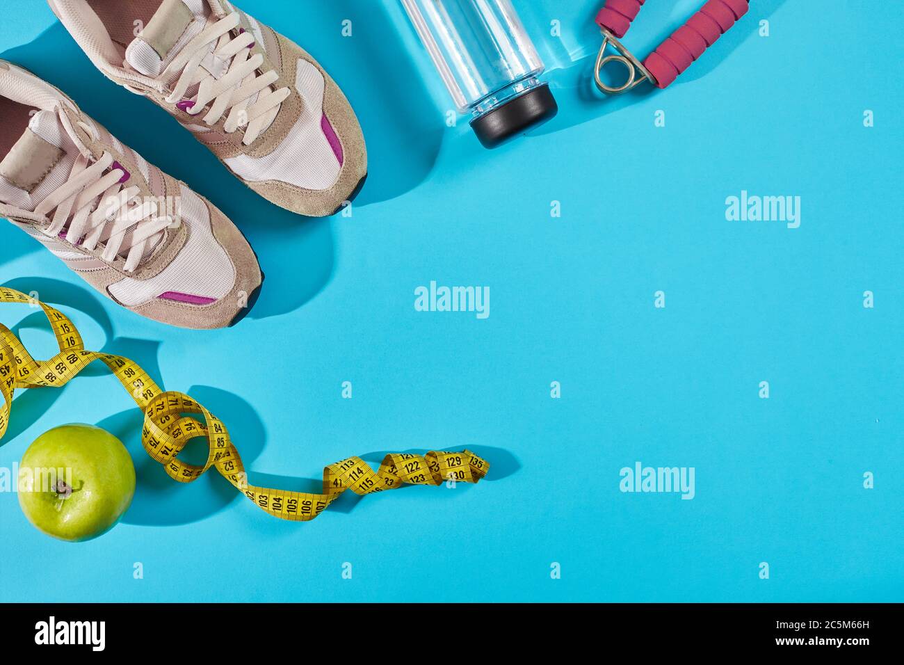 Baskets avec mètre ruban sur fond bleu cyan. Centimètre de couleur jaune  près des baskets blanches, gros plan Photo Stock - Alamy