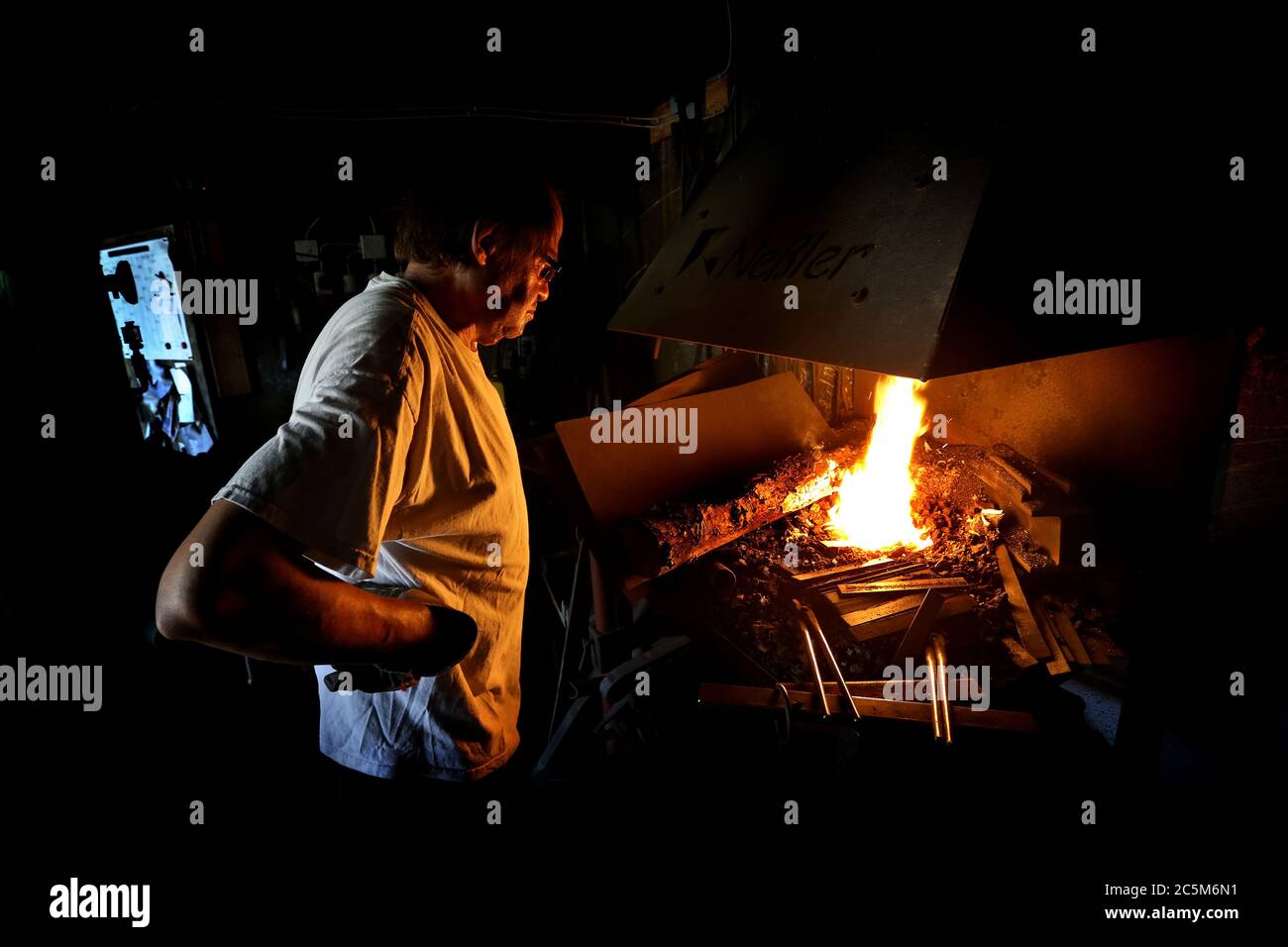Bad Hindelang, Allemagne. 02 juillet 2020. Konrad Neßler se tient dans sa forge à une cheminée dans laquelle il chauffe des tiges d'acier afin de former ensuite des poignées de casserole d'eux. Le forgeron de 57 ans travaille dans son atelier avec un four en pierre, des marteaux en bois lourds et de l'eau. (À dpa-KORR: 'L'artisanat ancien dans l'Allgäu: Quand l'amour pour le cuir rend votre doigt crocheté"). Crédit : Karl-Josef Hildenbrand/dpa/Alay Live News Banque D'Images