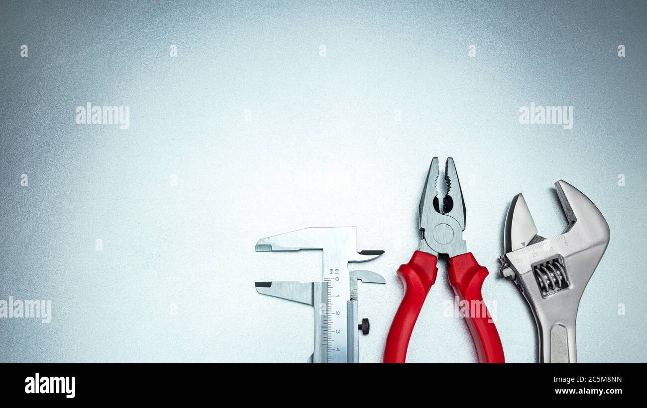 outils à main pied à coulisse, pince et clé réglable sur fond gris en métal, vue de dessus Banque D'Images