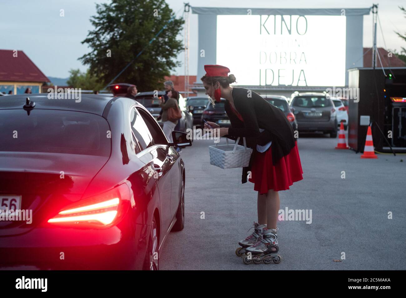 Ptuj, Slovénie. 03ème juillet 2020. Une serveuse prend une commande avant la projection d'un film 'Grease' avec John Travolta et Olivia Newton-John dans un parking de cinéma temporaire.en raison de la propagation du coronavirus (COVID-19), le City Cinema a organisé une projection en plein air. Crédit : SOPA Images Limited/Alamy Live News Banque D'Images