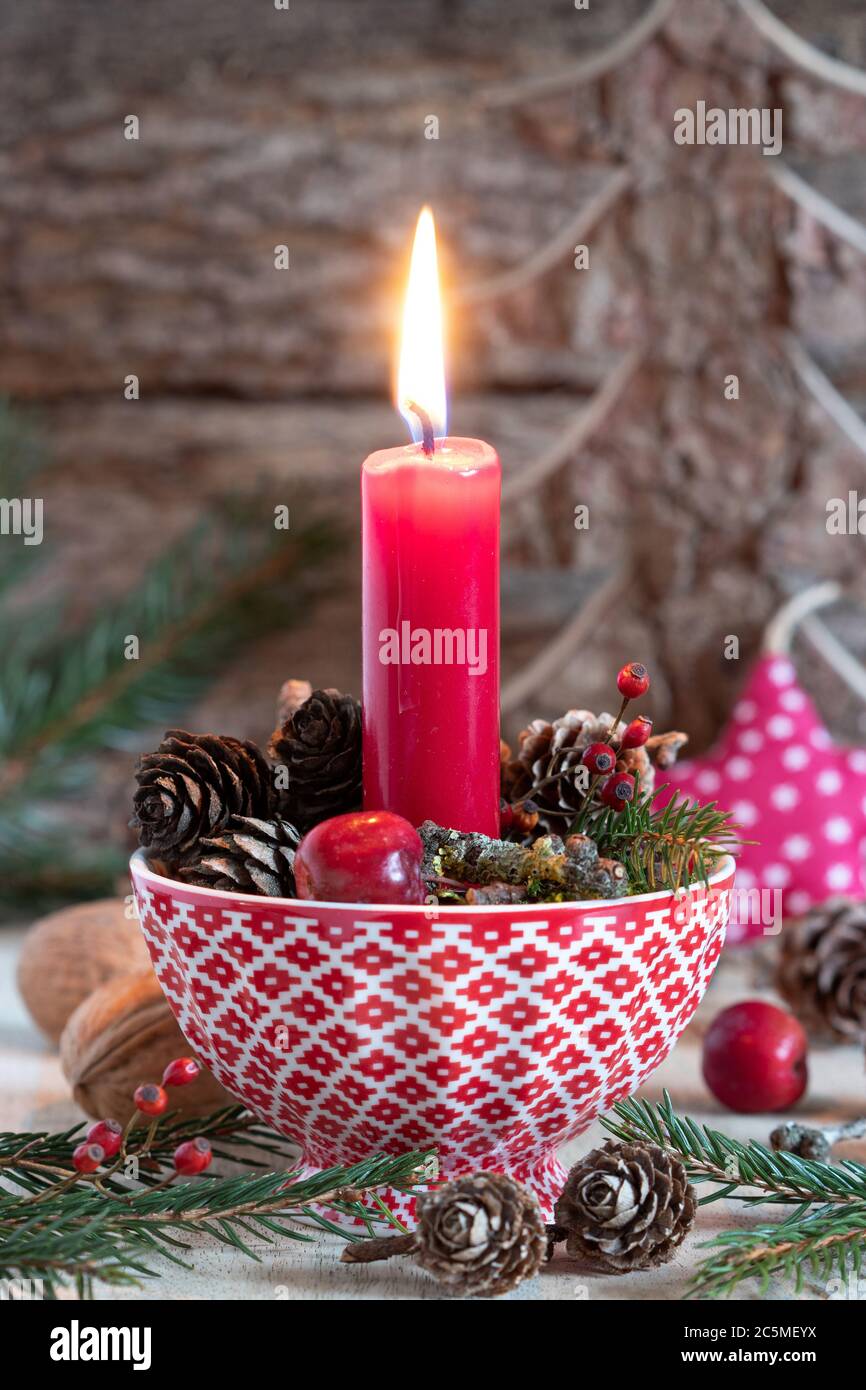 décoration de noël avec bougies rouges et cônes dans une tasse Banque D'Images