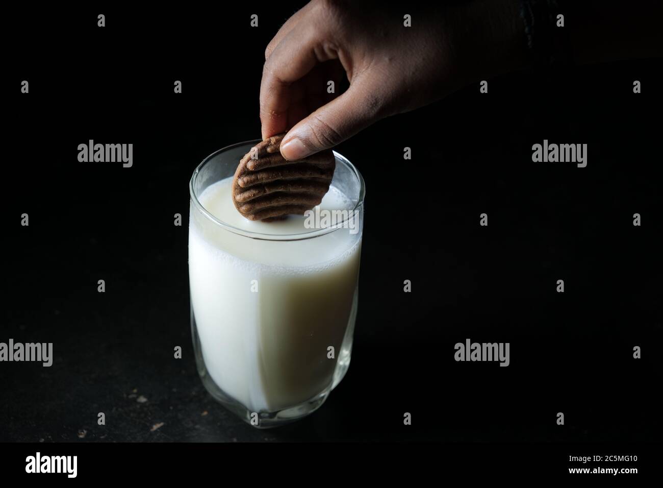 Biscuits trempez dans un verre de lait Banque D'Images