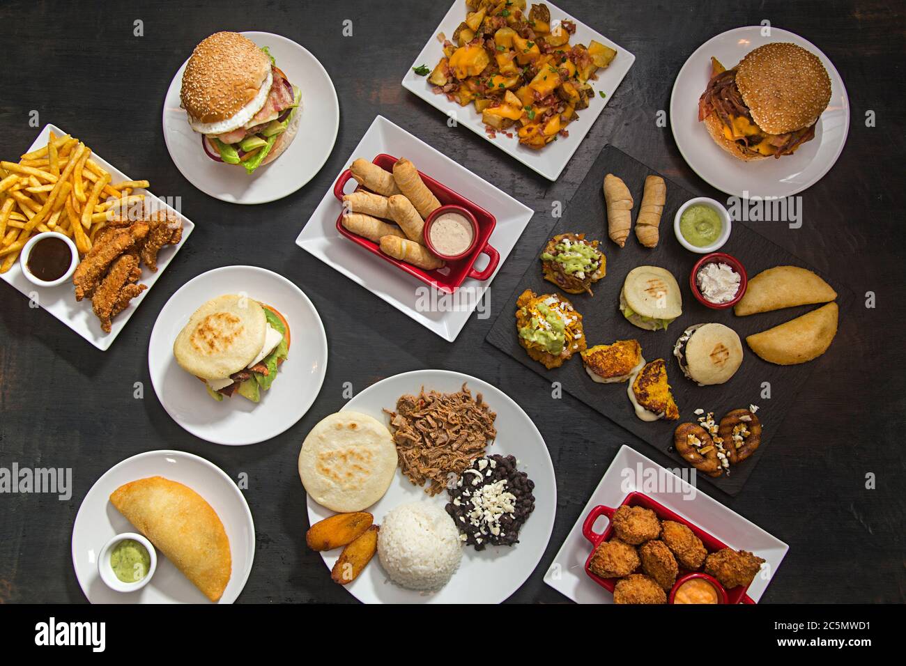 Table avec cuisine latino-américaine, arepa, tequeños, pabellón, cachapas. Vue d'en haut. Banque D'Images