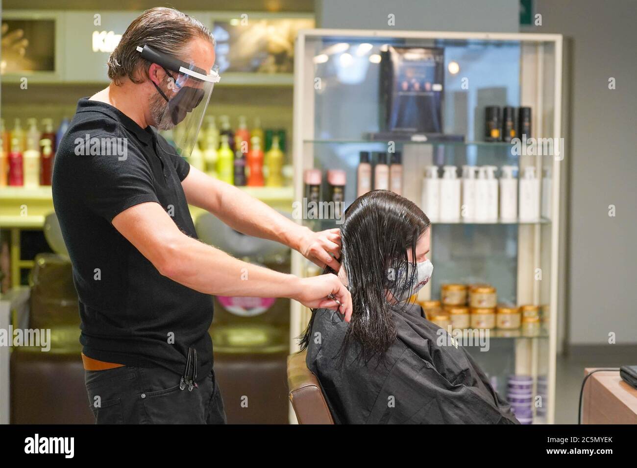 Sheffield, Royaume-Uni. 4 juillet 2020. Conrad Blandford, propriétaire du  salon de coiffure Conrad Blandford, Sheffield porte un équipement de  protection individuelle (EPI) et un masque facial protecteur lors de la  réouverture des