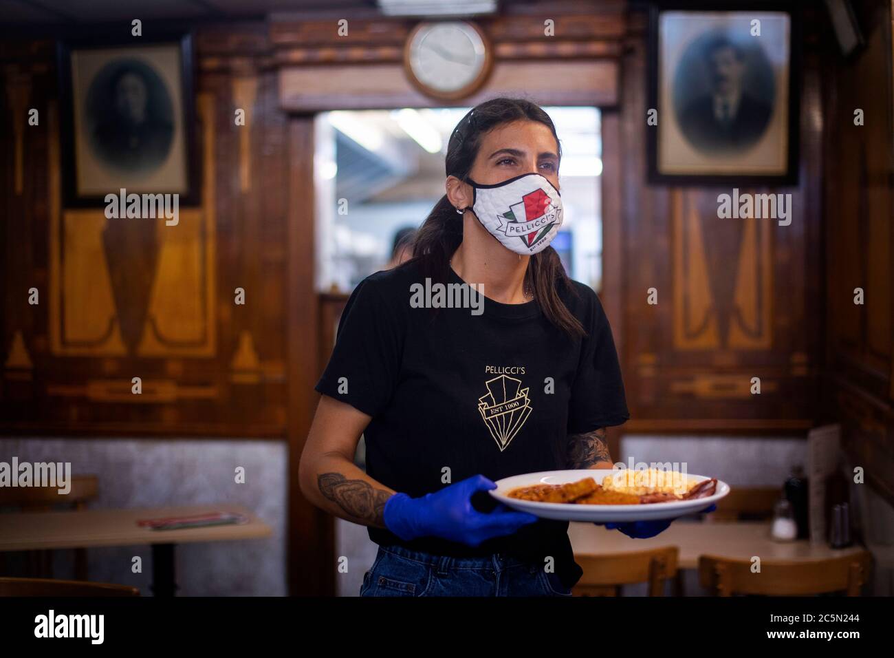 Un membre du personnel sert un petit déjeuner anglais complet à un client, le Pellicci's Cafe rouvre à Bethnal Green, dans l'est de Londres, car les restrictions de confinement du coronavirus sont assouplies dans toute l'Angleterre. Banque D'Images Un membre du personnel sert un petit déjeuner anglais complet à un client, le Pellicci's Cafe rouvre à Bethnal Green, dans l'est de Londres, car les restrictions de confinement du coronavirus sont assouplies dans toute l'Angleterre. Banque D'Images