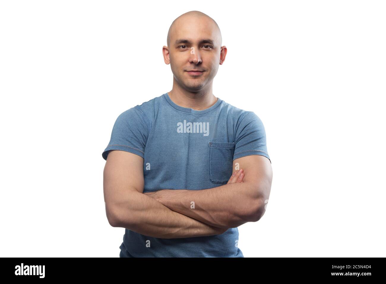 Image d'un jeune homme chauve avec bras croisés dans un t-shirt bleu Banque D'Images