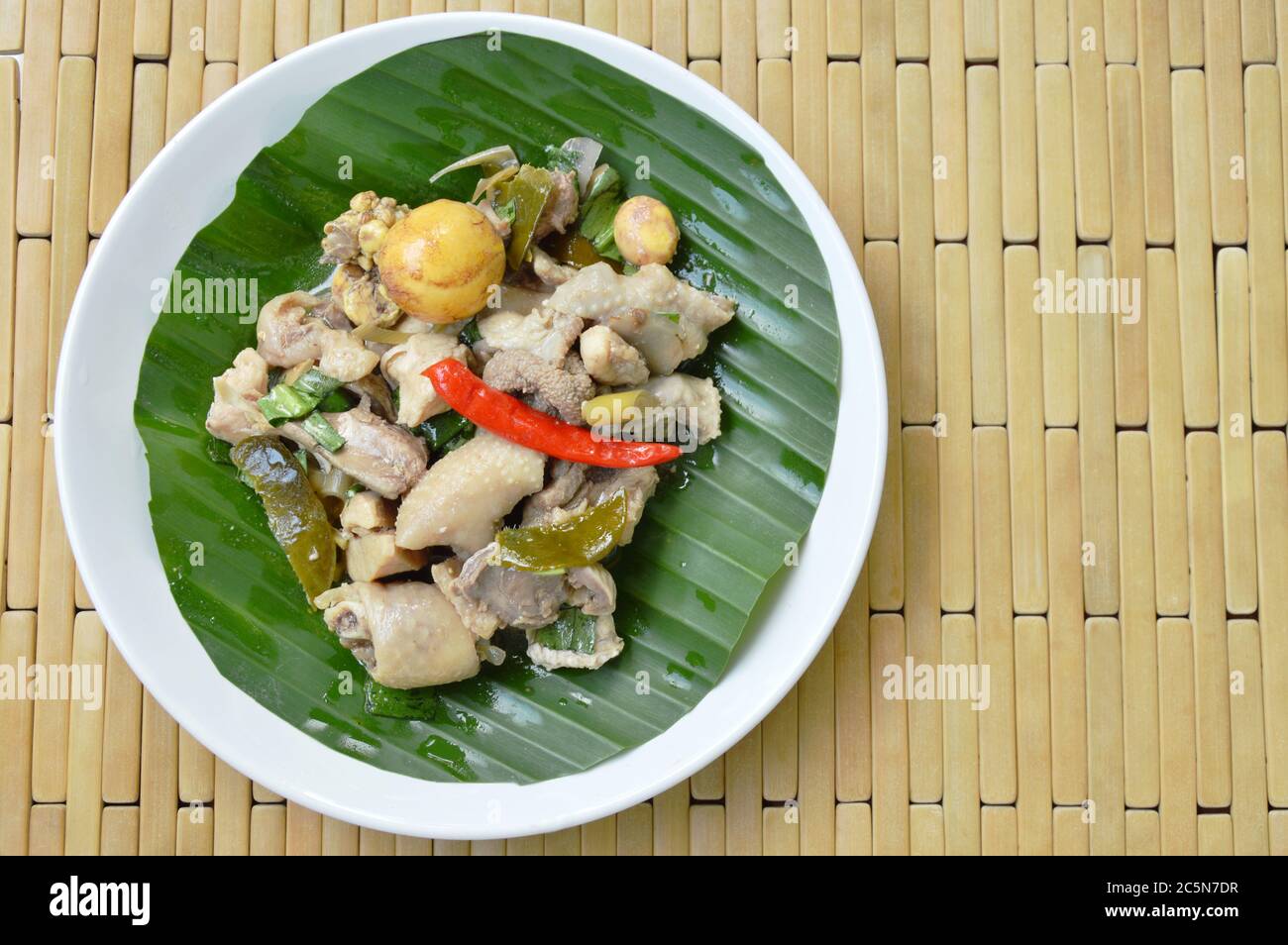 poulet cuit épicé et salade d'œufs sur feuille de banane dans l'assiette Banque D'Images
