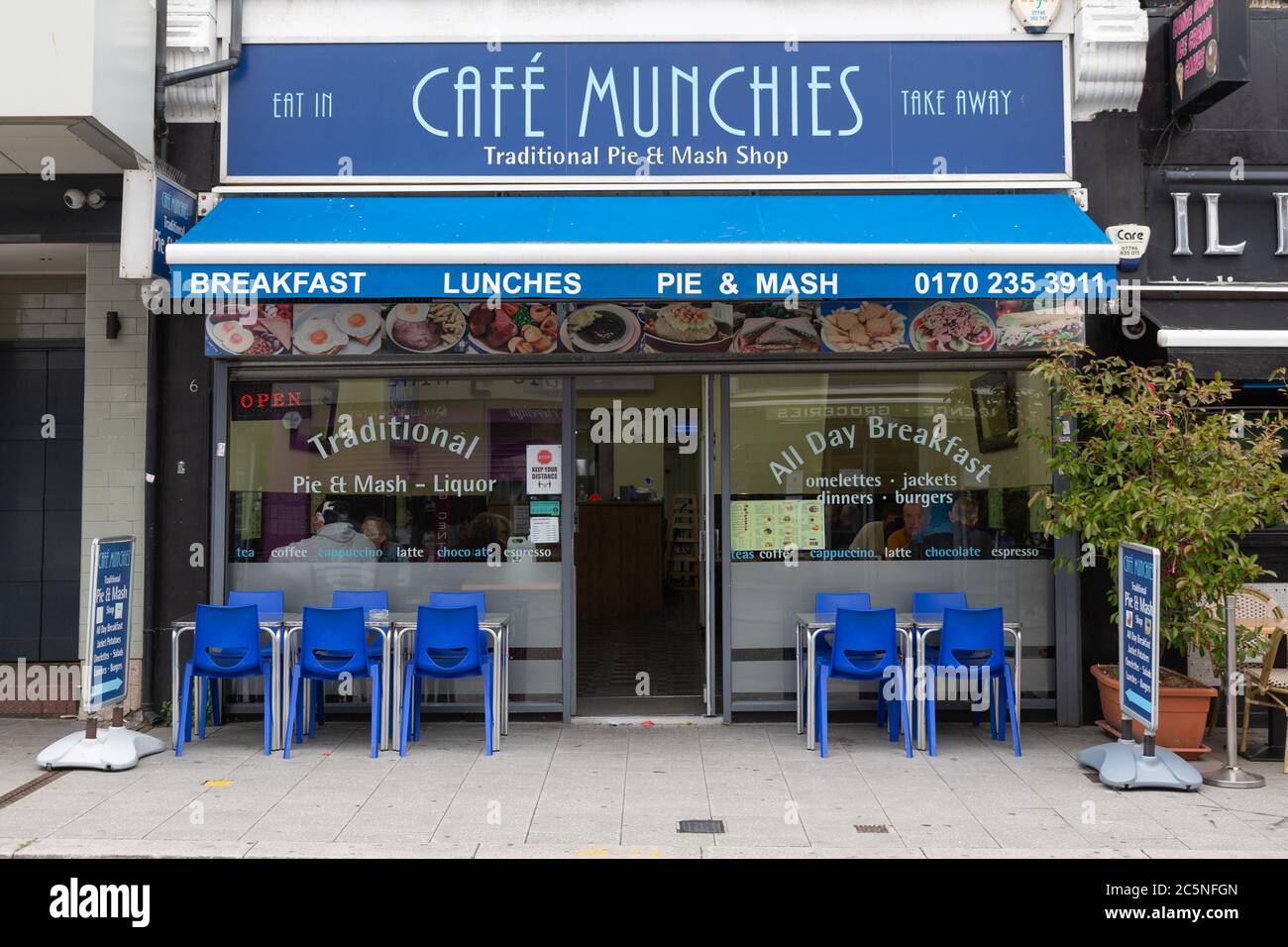 Southend-on-Sea, Royaume-Uni. 4 juillet 2020. Extérieur du Café Munchies, un magasin traditionnel de tartes et de mash à Southend-on-Sea, Essex, offrant un service de restauration sur place et de plats à emporter. Des places en plein air sont aménagées alors que le café rouvre à la suite de l’assouplissement des restrictions de confinement liées à la COVID-19. La signalétique promeut les petits déjeuners toute la journée, les tartes et purées traditionnelles avec de l'alcool et d'autres repas chauds. Les cafés sont ouverts pour les clients assis ou la première fois depuis le confinement pour la pandémie de coronavirus covid-19. Penelope Barritt/Alamy Live News Banque D'Images