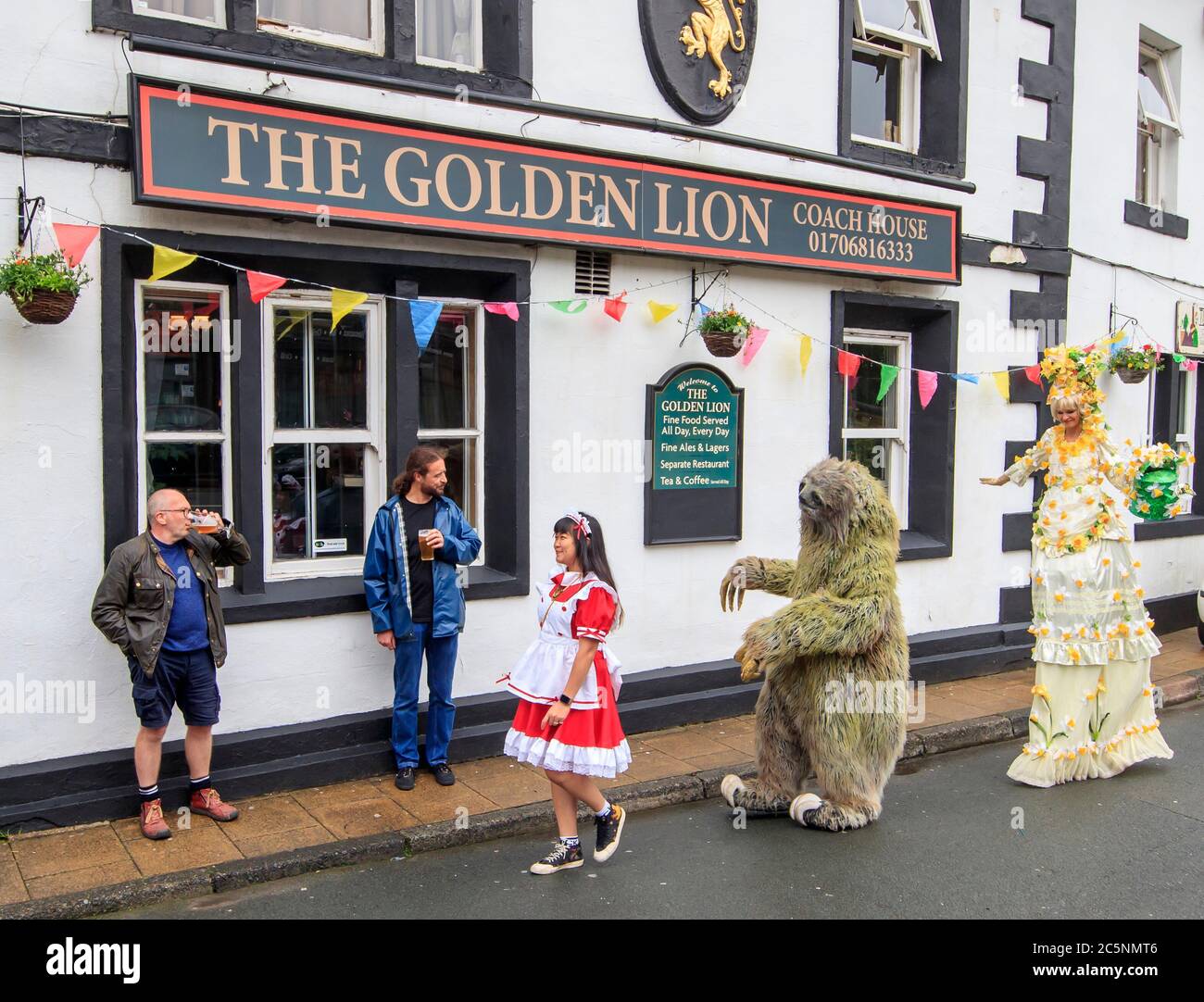 Les artistes de rue se produisent pour les clients devant le pub Golden Lion de Todmorden, West Yorkshire, alors qu'il rouvre à la suite de l'assouplissement des restrictions de confinement des coronavirus dans toute l'Angleterre. Banque D'Images