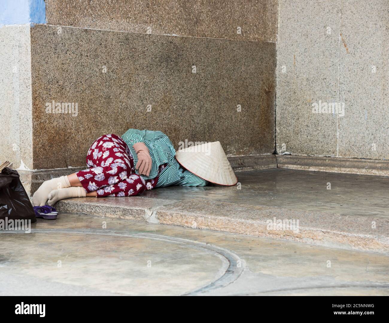 Femme vietnamienne sans abri locale dormant dans une porte pendant le temps chaud de jour dans Hoi an ville Vietnam Asie. Banque D'Images