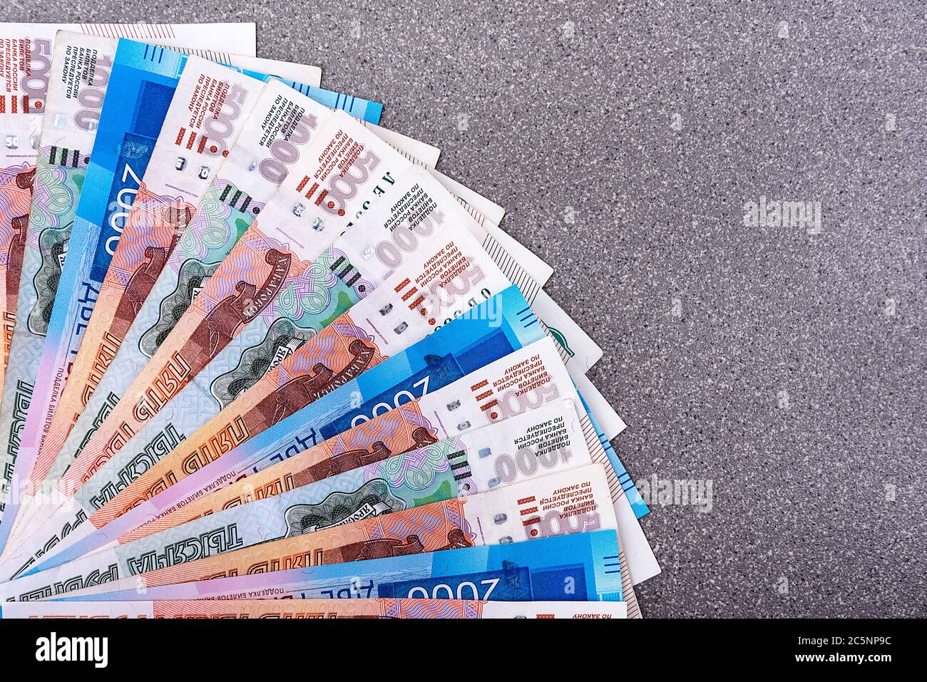 Monnaie russe, mille roubles, deux mille roubles, cinq mille roubles, image de fond, billets disposés en éventail sur fond gris. Je Banque D'Images