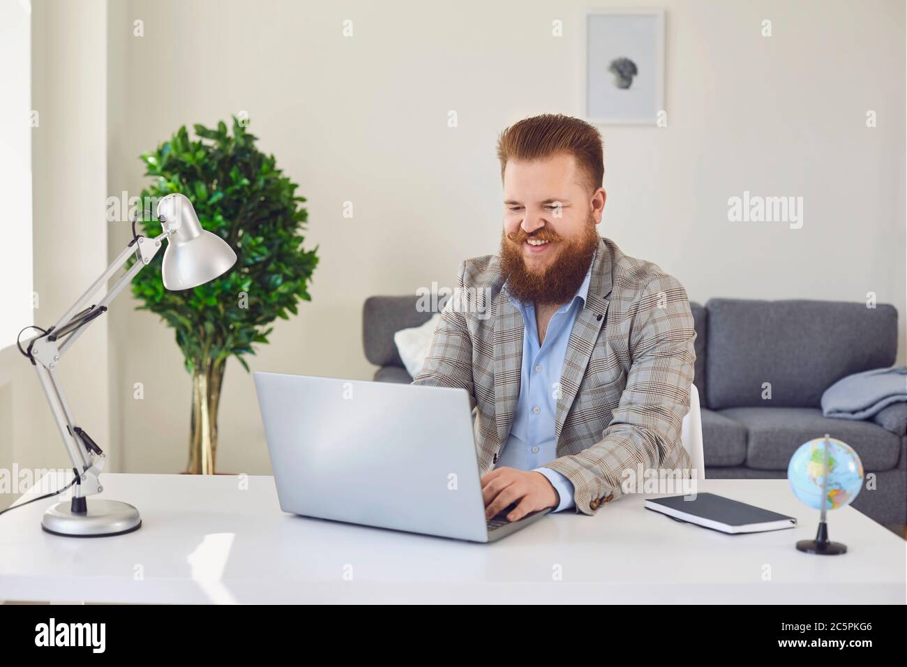 Homme travaillant en ligne à domicile.homme d'affaires de contenu tapant sur ordinateur portable. Banque D'Images