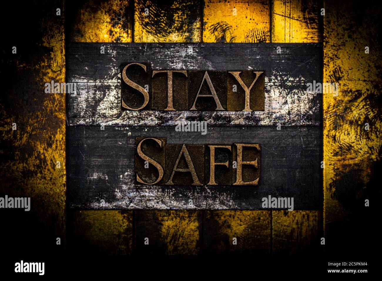 Texte Stay Safe composé de véritables lettres authentiques sur fond de cuivre et d'or texturé vintage argent Banque D'Images