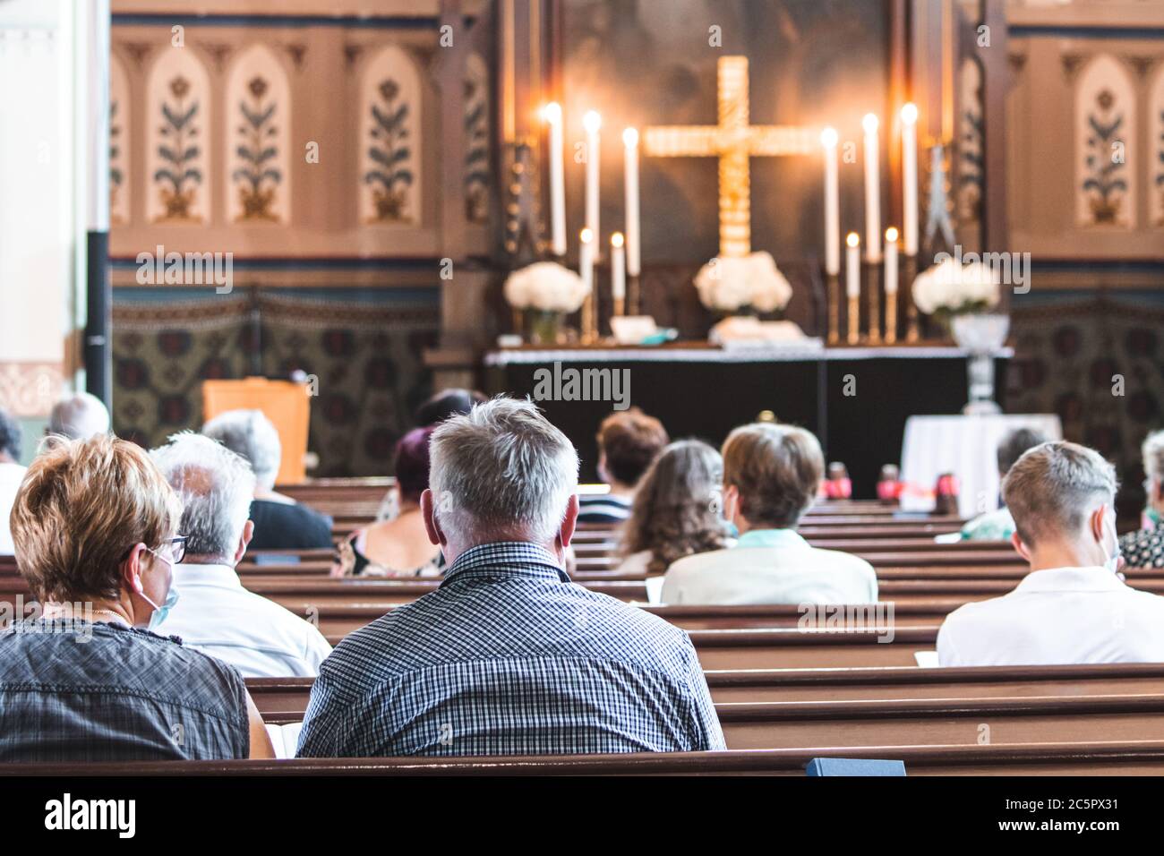 Messe dans l'église chrétienne pendant la pandémie du coronavirus Covid-19. Distance de sécurité personnelle avec les masques. Chruch pendant les pandémies Banque D'Images