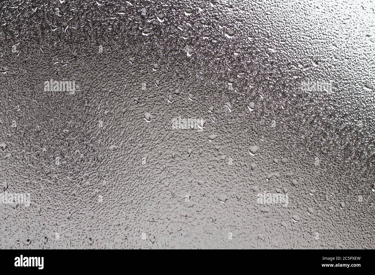 Photo de texture en verre dépoli avec arrière-plan flou et gouttes de pluie. Banque D'Images