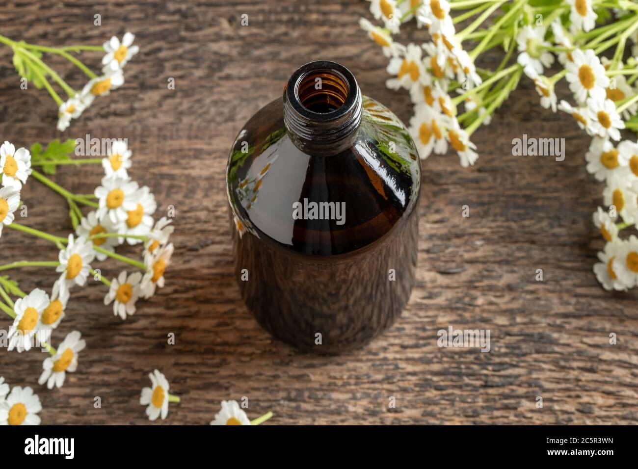 Une bouteille foncée de teinture avec plante fraîche de fiverthoud en fleurs Banque D'Images