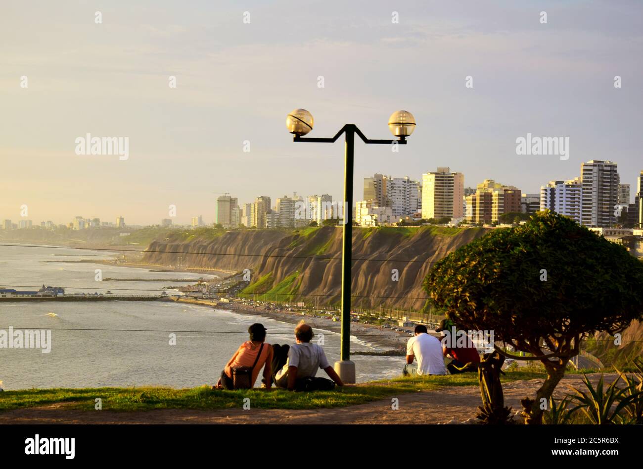 Les gens regardant la côte au coucher du soleil à Lima, Pérou Banque D'Images