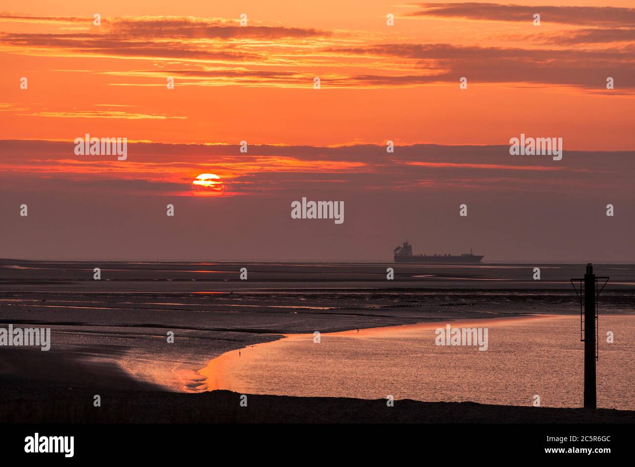 Vue sur la mer depuis Fleetwood sur la côte du Lancashire avec un bateau passant dans la mer irlandaise au coucher du soleil Banque D'Images