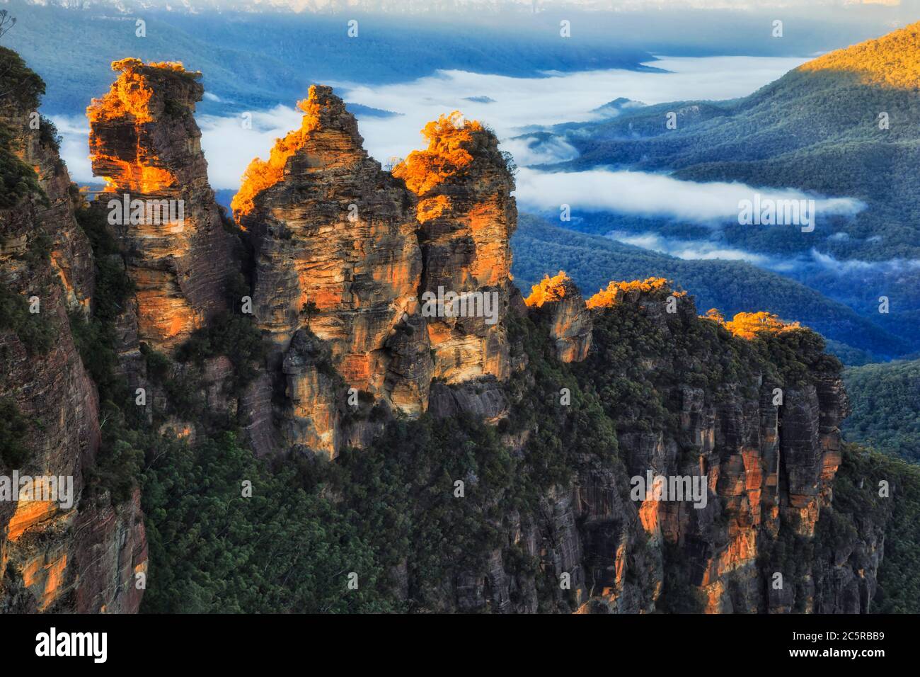 Formation rocheuse érodée surnommée Three Sisters dans le parc national des Blue Mountains d'Australie au lever du soleil. Banque D'Images