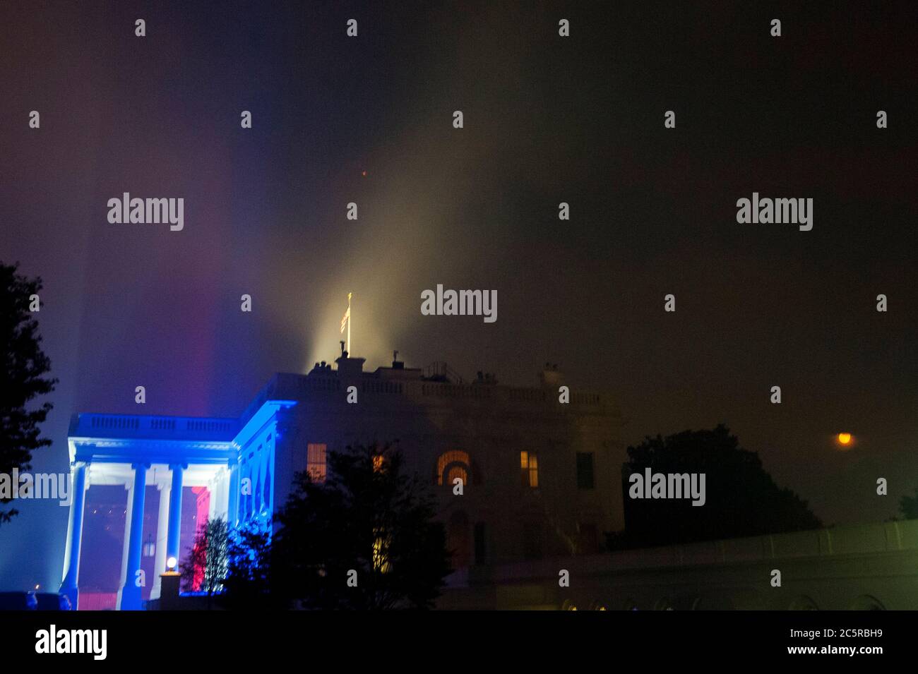 La Maison Blanche, éclairée dans les couleurs du 4 juillet, est partiellement enveloppée de fumée des allées de feux d'artifice au-dessus du National Mall à Washington, DC., samedi 4 juillet 2020. (Photo de Rod Lamkey Jr./SIPA USA) crédit: SIPA USA/Alay Live News Banque D'Images