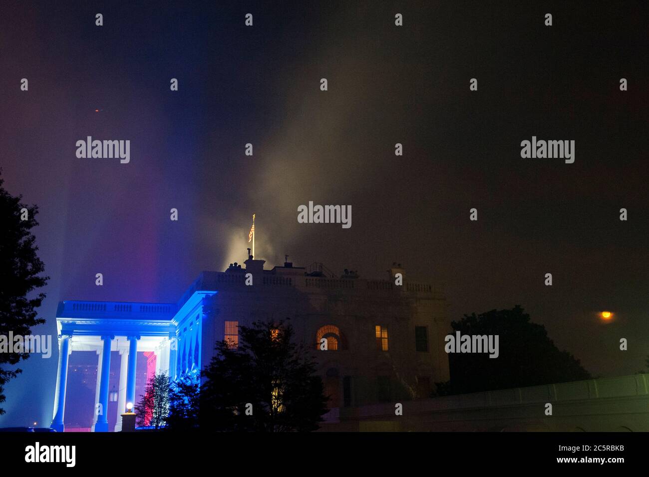 La Maison Blanche, éclairée dans les couleurs du 4 juillet, est partiellement enveloppée de fumée des allées de feux d'artifice au-dessus du National Mall à Washington, DC., samedi 4 juillet 2020. (Photo de Rod Lamkey Jr./SIPA USA) crédit: SIPA USA/Alay Live News Banque D'Images