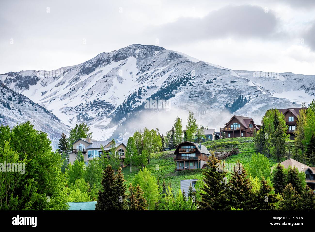 Crested Butte, États-Unis Colorado village en été avec des nuages et brouillard brumeux matin et des maisons sur la colline avec des arbres verts Banque D'Images