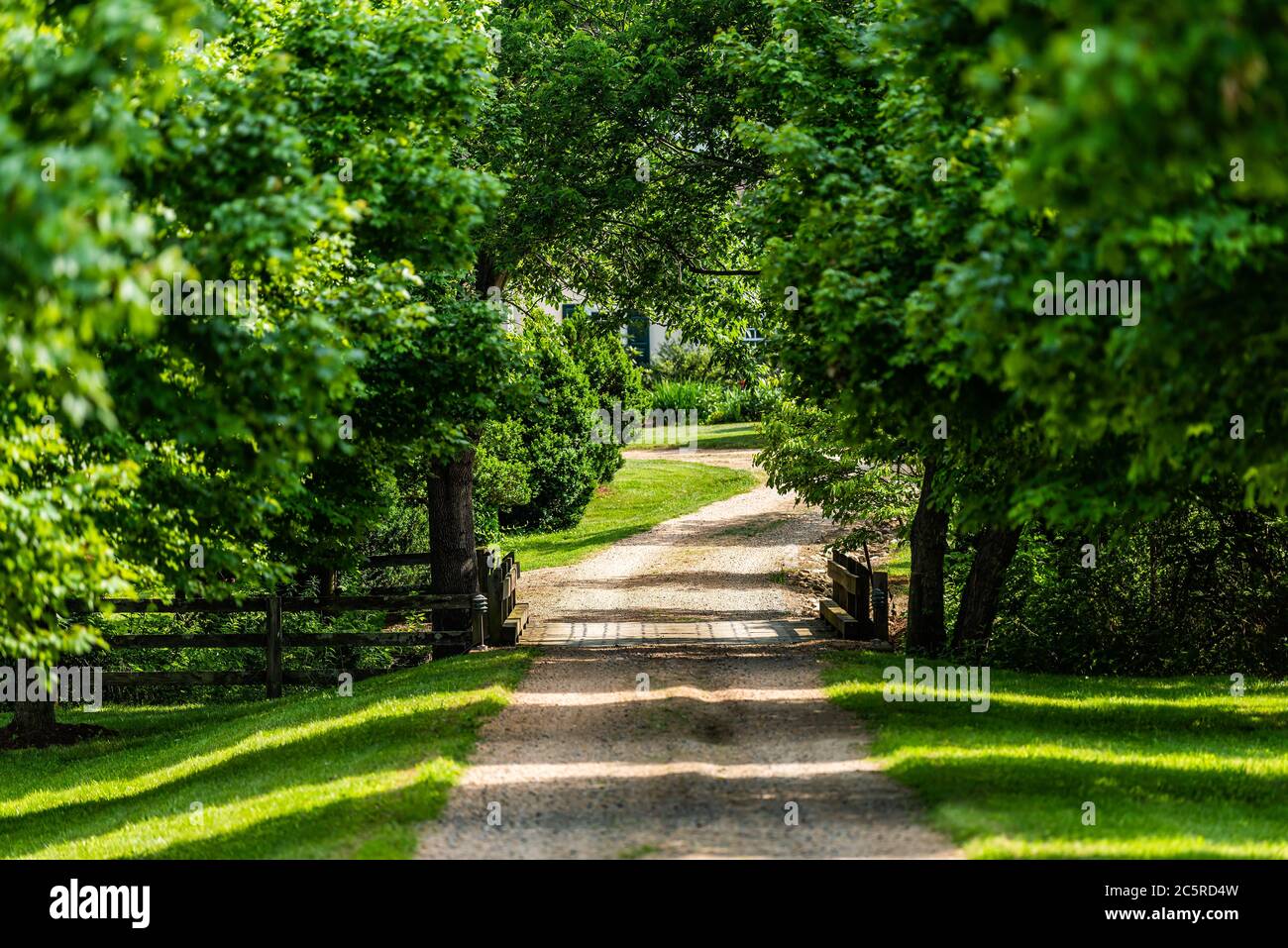 Entrée ouverte avec pont sur la rivière avec allée dans la campagne rurale dans Virginia Estate chemin de terre de gravier rue avec arbres verts luxuriants dedans Banque D'Images
