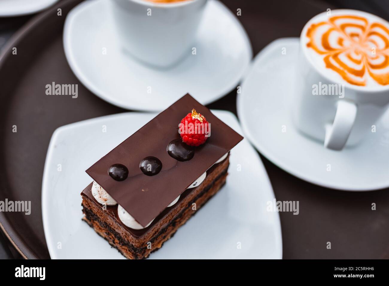 Tranche de gâteau au chocolat, panier à steak et donot avec café sur la table. Banque D'Images