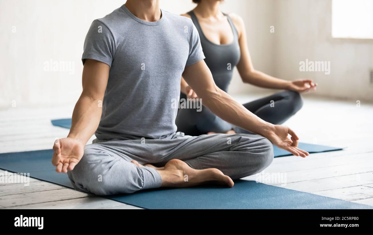 Jeune homme sportif fort méconnaissable assis en position lotus. Banque D'Images