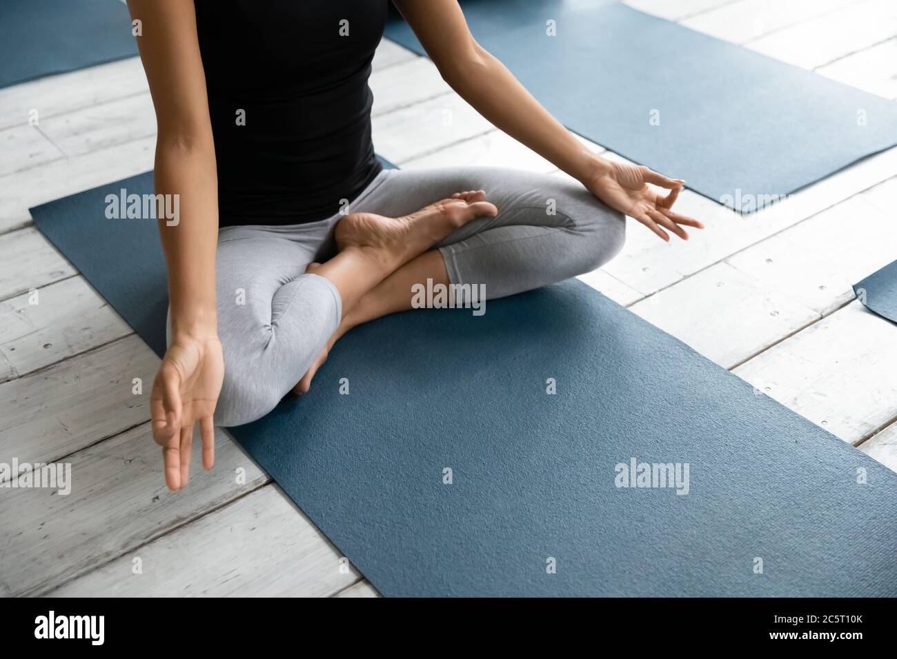 Jeune femme afro-américaine qui apprécie la méditation lors d'un cours de yoga. Banque D'Images