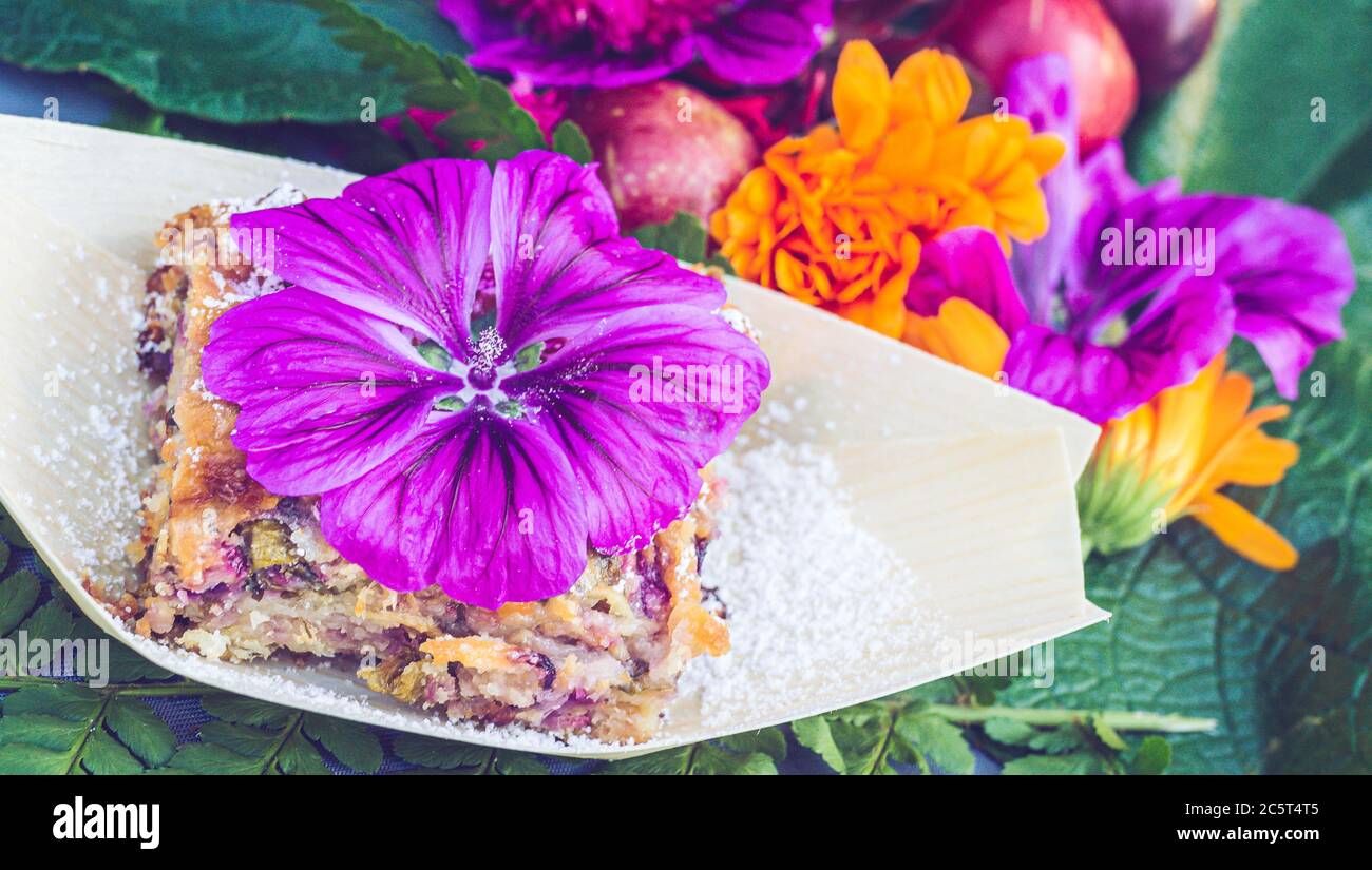 Doux avec du malow et des amandes.assiette décorée de fleurs de malow. Fleurs comestibles. Fleurs d'été Banque D'Images