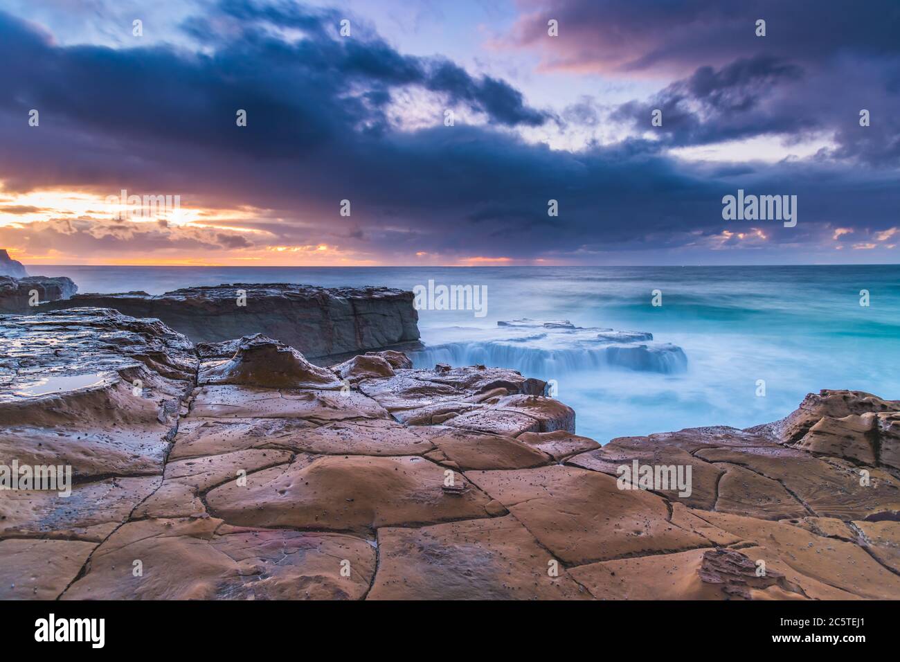 Lever de soleil nuageux depuis North Avoca Beach sur la côte centrale, Nouvelle-Galles du Sud, Australie. Banque D'Images