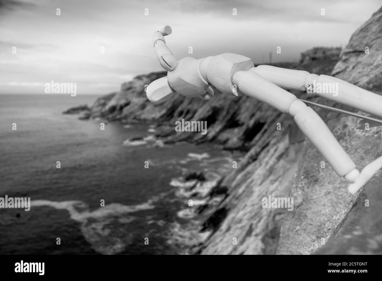 Mannequin en bois posé sur une falaise avec une belle mer brumeuse depuis un point de vue sur une plage de Mossel Bay Banque D'Images