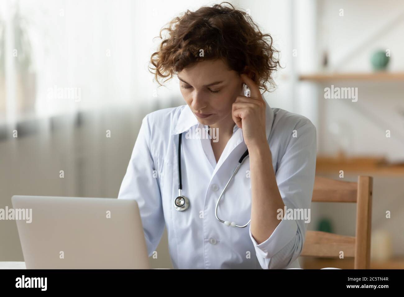 Une femme pensive médecin travaille sur la pensée d'un ordinateur portable Banque D'Images